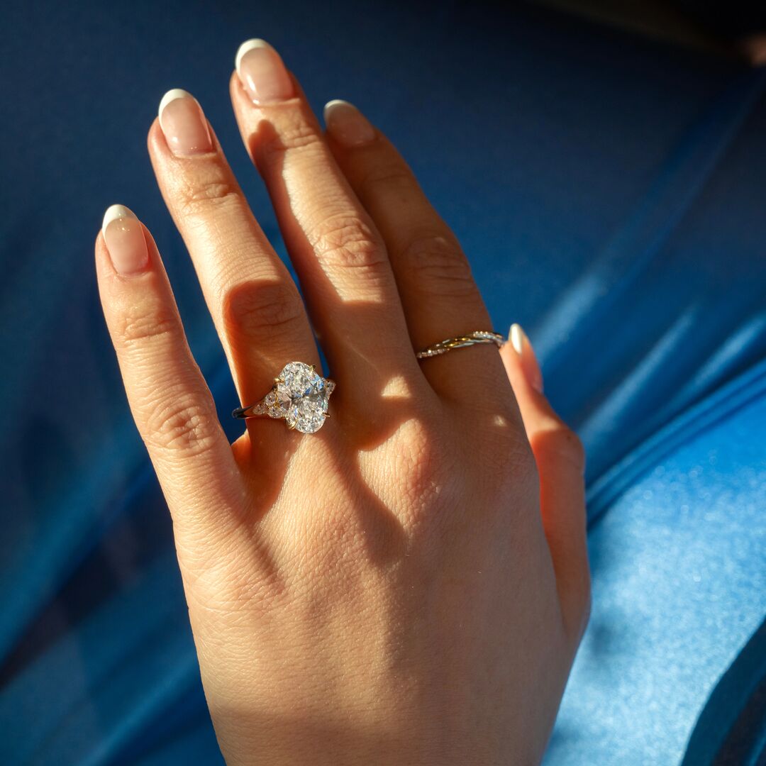 Spring2026_Internal15-Feed-square | Frank Darling Hang with oval cut diamond ring against a blue backdrop