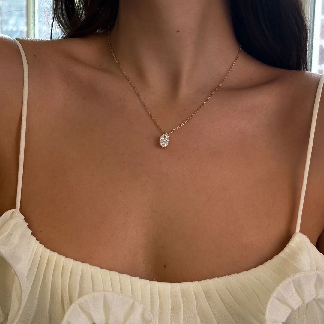 oval-pendant-Feed-square | Frank Darling woman in a pale yellow top wears a delicate oval moissanite pendant